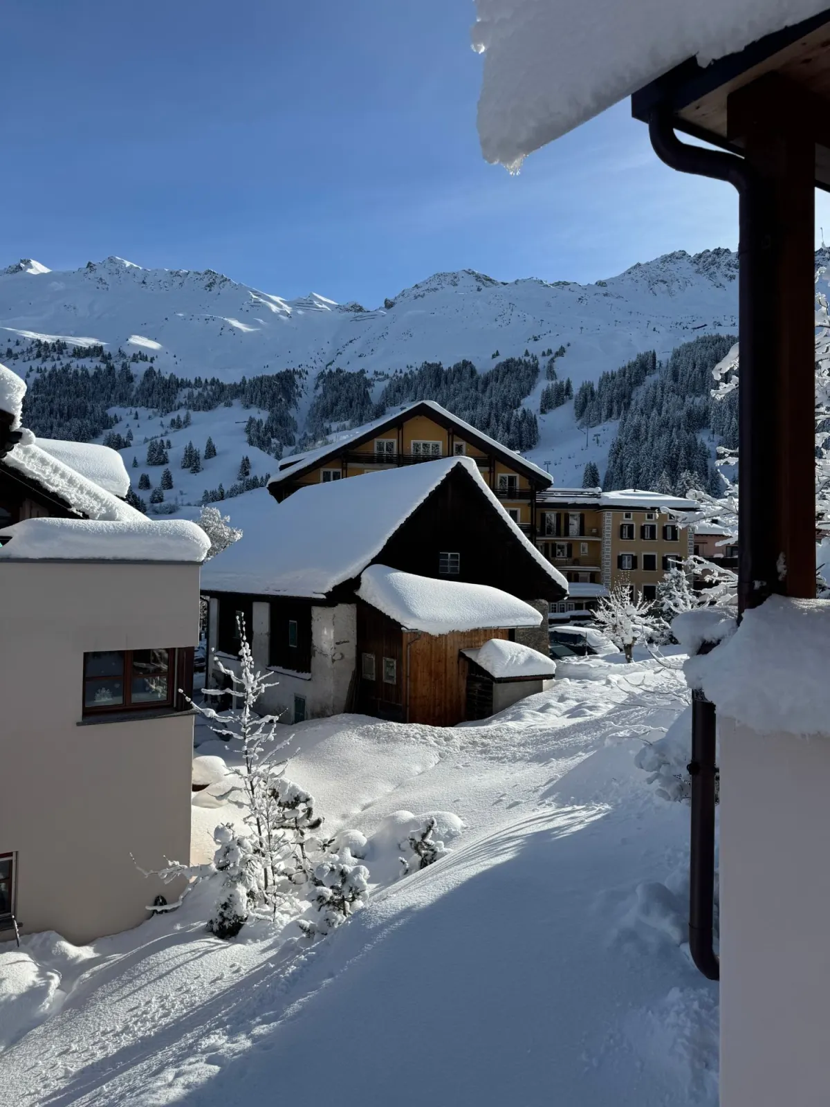 Blick vom Haus auf die verschneiten Skipisten und Lifte